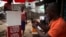 FILE - A man checks out a mobile phone at a kiosk in Sierra Leone's capital, Freetown. The administration on Thursday sharply denied reports that it planned to gag citizens from freely expressing their views on social media platforms.