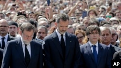 Raja Felipe dari Spanyol, tengah, PM Mariano Rajoy, kiri tengah, dan Presiden kawasan Catalonia, Carles Puigdemont, kanan tengah bergabung dengan warga untuk mengheningkan cipta untuk mengenang serangan teroris di Las Ramblas, Barcelona, Spanyol, 18 Agustus 2017 (foto: AP Photo/Manu Fernandez)