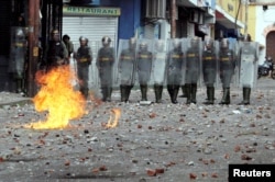 Security forces look on while clashing with opposition supporters participating in a rally against Venezuelan President Nicolas Maduro's government and to commemorate the 61st anniversary of the end of the dictatorship of Marcos Perez Jimenez in Tachira, Venezuela, Jan. 23, 2019.