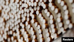 FILE - Cigarettes are seen during the manufacturing process in the British American Tobacco Cigarette Factory (BAT) in Bayreuth, southern Germany. Japan's health minister has said the government is eager to stamp out smoking in public by the time the capital hosts the Olympics. 