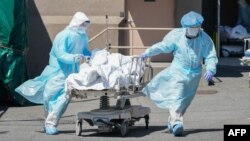 រូបឯកសារ៖ បុគ្គលិកពេទ្យបញ្ជូនសាកសពអ្នកជំងឺនៃជំងឺកូវីដ១៩ ដែលបានស្លាប់នៅមន្ទីរពេទ្យ Wyckoff ទីក្រុង Brooklyn រដ្ឋញូវយ៉ក កាលពីថ្ងៃទី៦ ខែមេសា ឆ្នាំ២០២០។