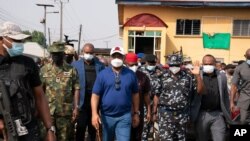 Imo state Gov. Hope Uzodinma, center, inspects the scene of an attack at the police command headquarters in Owerri, Nigeria, on April 5, 2021. 