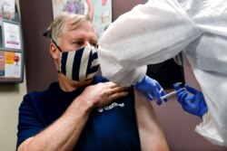 FILE - VWade Bardo of Erin, N.Y., gets an injection as a study of a possible COVID-19 vaccine gets under way in Binghamton, N.Y., July 27, 2020.