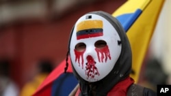 Seorang demonstran mengenakan pelindung wajah hockey dalam demo anti-pemerintah di Bogota, Kolombia, Senin, 21 September 2020. (Foto: AP)