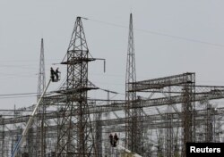 Karyawan bekerja di jaringan listrik di dekat Pembangkit Listrik Tenaga Nuklir Zaporizhzhia selama konflik Ukraina-Rusia di luar kota Enerhodar yang dikuasai Rusia di wilayah Zaporizhzhia, Ukraina, 22 Agustus 2022. (Foto: REUTERS/Alexander Ermochenko)