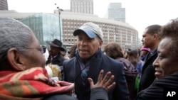 Former Mass. Gov. Deval Patrick, center, greets people in a crowd, April 2, 2018, before a remembrance on City Hall Plaza, in Boston.