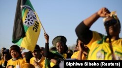 Des partisans de l'African National Congress brandissent le drapeau du parti lors de la campagne de l'ANC à Atteridgeville, un canton situé à l'ouest de Pretoria, en Afrique du Sud, le 5 juillet 2016.