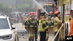 Petugas pemadam kebakaran tengah berupaya memadamkan api di pabrik baterai lithium di Hwaseong, Korea Selatan, 24 Juni 2024. (AFP)