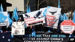 FILE - Uighurs and their supporters rally across the street from United Nations headquarters in New York, March 15, 2018. 