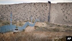 FILE - A U.S. Border Patrol agent drives near the U.S.-Mexico border fence in Sunland Park, New Mexico, Jan. 4, 2016. Trump pledges to replace the fence with a wall that Mexico will pay for.