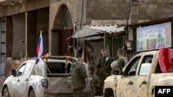 12月12日，俄罗斯士兵站在军用皮卡车旁，准备撤离叙利亚东北部卡米什利的一处阵地。