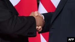 도널드 트럼프 미국 대통령(오른쪽)과 김정은 북한 국무위원장이 12일 싱가포르 카펠라 호텔에서 열린 미북 정상회담에서 악수하고 있다.