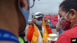 Veteran Sherpa guide Kami Rita, center, who returned from the mountains on a helicopter arrives at the airport in Kathmandu, Nepal, May 25, 2021.