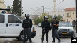 FILE - Israeli policemen stand on guard in the village of Arara, northern Israel, Friday, Jan. 8, 2016. 