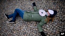 Aktivistkinja Amnesti Internešnala leži na zemlji u Berlinu tokom demonstracija u sklopu obeležavanja 8. marta