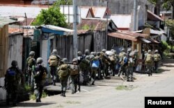 FILE - Philippine Marines advance their positions as more soldiers reinforce to fight the Maute group in Marawi City in southern Philippines May 29, 2017.