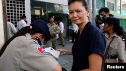 Pakistani laborers transport the front portion of a vehicle using a handcart at a road in Peshawar.