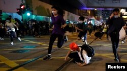 Pro-democracy demonstrators run away as riot police disperse them with pepper-spray pellet during a protest to mark first anniversary of a mass rally against a now-withdrawn extradition bill, in Hong Kong, China, June 9, 2020.