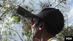 People viewed the eclipse through everything from cellophane to strips of developed film, in Pakwach, Uganda, Nov. 3, 2013. (H. Heuler/VOA News)