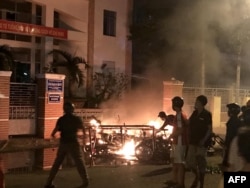 Picture taken on June 10, 2018 shows protesters burning motorcycles in front of a provincial office in Vietnam's south central coast Binh Thuan province in response to legislation on three special economic zones that would grant 99-year leases.