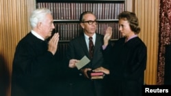 FILE - Sandra Day O'Connor, right, is sworn in as a Supreme Court Justice by Chief Justice Warren Burger as her husband, John O'Connor, looks on, in Washington, Sept. 25, 1981.