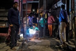 FILE - Mulsims erect a steel gate in a lane following Hindu-Muslim clashes triggered by a new citizenship law, in Chand Bagh in the riot-affected northeast of New Delhi, India, March 4, 2020.