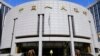 FILE - A woman walks out of the headquarters of the People's Bank of China (PBOC), the central bank, in Beijing.