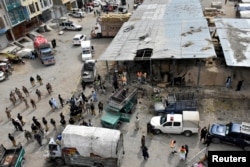 FILE - Rescue workers and army soldiers gather at the site of a blast at a vegetable market in Quetta, Pakistan, April 12, 2019.