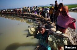 Rohingya refugees make their way to a refugee camp after crossing the Bangladesh-Myanmar border in Palong Khali, near Cox's Bazar, Bangladesh, Nov. 3, 2017.