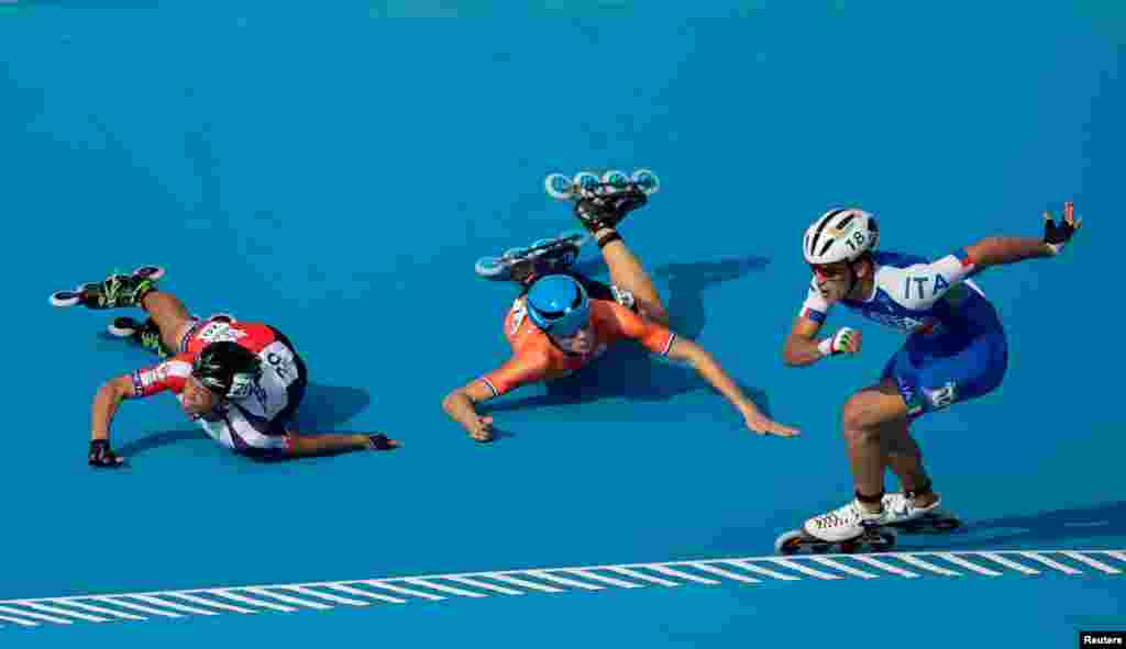 Vincenzo Maiorca of Italy takes the lead as Chiawei Chang of Taiwan and Merijn Scheperkamp of the Netherlands fall during the Roller Speed Skating Mens Combined Speed Event Final at the Paseo De La Costa during the Youth Olympic Games, Buenos Aires, Argentina, Oct. 8, 2018.