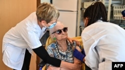 A doctor administers a dose of Pfizer-BioNtech coronavirus disease (Covid-19) vaccine to a woman on Jan. 4, 2020 at the Antonin Balmes gerontology center in Montpellier in the south of France.