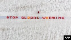 រូបឯកសារ៖ បដា​បង្ហាញ​ពី​វិធានការ​ទប់ទល់​នឹង​បម្រែបម្រួល​អាកាសធាតុ​ ដែល​ត្រូវ​បាន​ដាក់​បង្ហាញ​នៅ​ភ្នំទឹកកក Aletsch Glacier ប្រទេស​ស្វីស កាល​ពី​ថ្ងៃ​ទី១៣ ខែ​សីហា ឆ្នាំ​២០១៨។