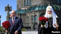 რუსეთის პრეზიდენტი ვლადიმირ პუტინი (მარცხნივ) და პატრიარქი კირილე (მარჯვნივ) რუსეთის არმიის საკათედრო ტაძართან. 22 ივნისი, 2020 წელი.