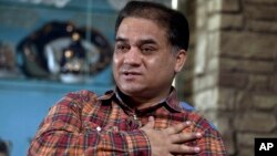FILE - Ilham Tohti, an outspoken scholar of China's Turkic Uighur ethnic minority, speaks during an interview at his home in Beijing, China.
