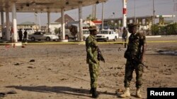 FILE - Members of the military stand at the scene of an explosion near a gas station in Kano, Nigeria, Nov. 15, 2014. 