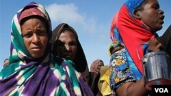Wanita dan anak-anak mengantri untuk menerima bantuan makanan yang dibagikan di Mogadishu.