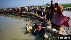FILE - Rohingya refugees make their way to a refugee camp after crossing the Bangladesh-Myanmar border in Palong Khali, near Cox's Bazar, Bangladesh, Nov. 3, 2017. 