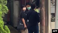 This video frame grab taken from AFPTV footage shows Chow Hang Tung, left, leader of the Hong Kong Alliance in Support of Patriotic Democratic Movements of China, being led away by police after being detained in Hong Kong on June 4, 2021.