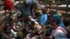 FILE - People, consisting mostly of women and children, sit at the back of a truck as the prepare to flee sectarian violence in a convoy escorted by African Union (AU) peacekeepers towards the border with Cameroon, in the town of Bouar, west of the Central African Republic.