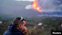 A man looks out on the Cumbre Vieja volcano as continues to erupt, on the Canary Island of La Palma, as seen from Tacande de Arriba, Spain, Oct. 2, 2021. 