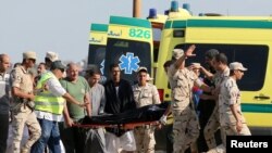 Une secouriste porte un corps dans une ambulance après qu'un bateau se soit renversé au large des côtés egyptienne, à Al-Beheira, Egypte, le 22 septembre 2016