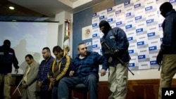 Jesus Zambada Garcia (tengah) satu dari empat pemimpin kartel Sinaloa dikawal oleh empat penjaga bermasker saat dihadapkan di depan wartawan pada konferensi pers pasca penangkapan mereka di Meksiko, 22 Oktober 2008 (Foto: dok).
