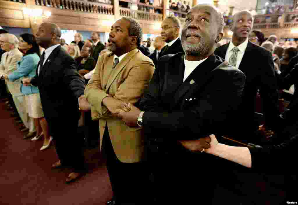 Reverend Richard Harkness holds hands with Reverend Jack Lewin (2ndR)as the whole church sings "We Shall Overcome" at the close of a prayer vigil held at Morris Brown AME Church in Charleston, South Carolina, June 18, 2015.