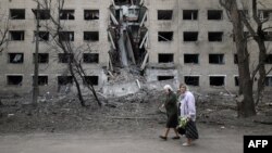 Starice hodaju pored hostela uništenog tokom ruskog bombardovanja grada Seljdove u regionu Donjeck, 14. aprila 2024. godine. (Foto: AFP/Anatolii Stepanov)