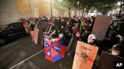 Demonstrators shield themselves from advancing federal officers during a Black Lives Matter protest July 28, 2020, in Portland, Ore. 