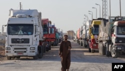 รถบรรทุกขนส่งความช่วยเหลือจอดรออยู่ที่จุดผ่านแดนราฟาห์ ทางภาคใต้ของกาซ่า ติดกับพรมแดนอียิปต์ เมื่อวันที่ 11 ธ.ค. 2023 (ภาพจากเอเอฟพี)
