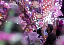 Seorang pria memeriksa lentera Ramadhan tradisional, yang disebut "fanous", di sebuah kios toko menjelang bulan suci Ramadhan, di tengah pandemi COVID-19 di Kairo, Mesir, 8 April 2021. (Foto: REUTERS/Mohamed Abd El Ghany )