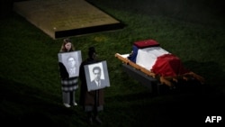 Teenagers hold portraits of Missak Manouchian, front, a hero of the French Resistance who was executed by occupying Nazi forces in 1944, and of a fellow executed Resistance fighter, during a ceremony on Feb. 20, 2024, on the eve of Manouchian's entombment to the Panthéon. 