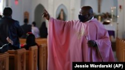 Le père Athanasius Abanulo, originaire du Nigeria, salue ses paroissiens après la messe du dimanche 12 décembre 2021, à l'église catholique Immaculate Conception de Wedowee, en Alabama. 