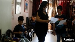 Gabriel Moncada and his mother Cecilia Gonzalez look at his drawings at their home in Caracas, Venezuela October 15, 2018. Picture taken October 15, 2018. REUTERS/Marco Bello